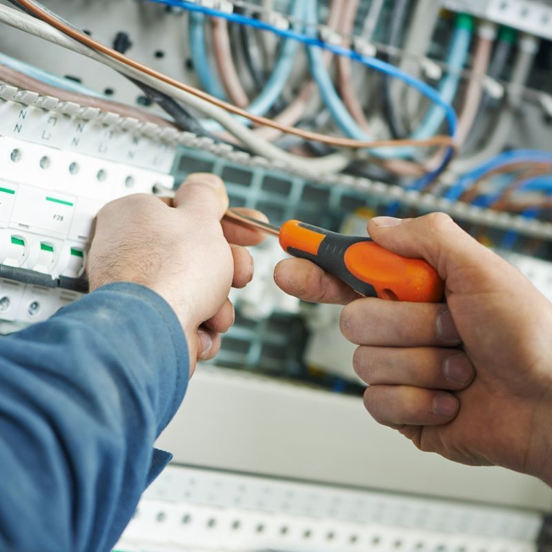 Elektrotechniker bei der Arbeit an einem elektrischen Panel, um die Verkabelung und Schaltungen zu überprüfen